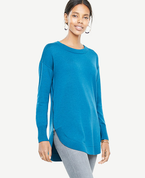 Our extrafine merino wool sweater is finished with a side zippered round hem for extra flattering effect - and endless versatility. Jewel neck. Long sleeves. Exposed metal side zippers. Shirttail hem. 30 long.