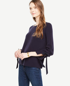 Meet your real-life uniform: this is Luxewear. Every day. Every wear. Our ruched tie sleeve sweater adds style and texture to your wardrobe - any day of the week. Jewel neck. Long raglan sleeves with slit cuffs and tunneled ties. 22 1/2 long.