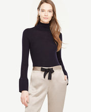 A sleek turtleneck meets wide flare cuffs for a perfect play on volume and proportion. Turtleneck. Long sleeves with flare cuffs. 25 long.