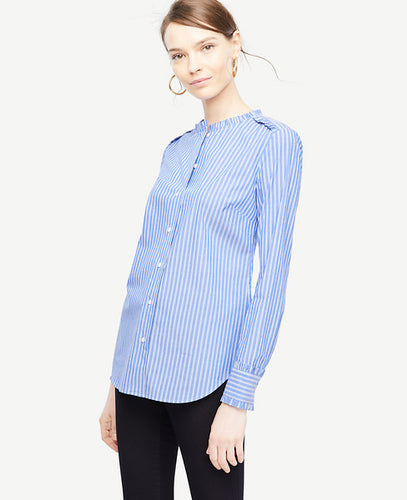 A crisp cotton shirt is an essential every closet needs - especially when it's embellished with pretty ruffles. Ruffle stand collar. Long sleeves with shirred ruffle cuffs and button closure. Button front. Shirred ruffle front shoulder yoke. Back yoke. Shirttail hem. 26 1/4 long.