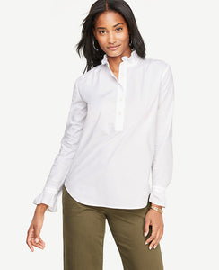 A ruffled collar and easy popover silhouette make this crisp poplin blouse one of our season's favorites. Ruffle stand collar. Long sleeves with button closure and ruffle cuffs. Button front placket. Shirred front shoulder seams. Back yoke with shirring beneath. Shirttail hem. 26 long.