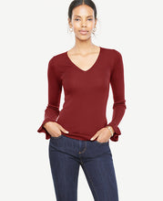 We gave this extrafine merino wool sweater a feminine twist with ruffled cuffs - and a flattering ribbed stitch. V-neck. Long sleeves with ruffle cuffs. 25 long.