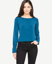 Ruffle cuffs bring modern refinement to this beautifully shirred knit top. Encased elastic shirred jewel neck. Long sleeves with encased elastic shirred cuffs. Back slit with hook-and-eye closure. Shirttail hem. 24 1/2 long.