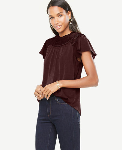 Soft flutter sleeves meet a crisply pleated neckline for a modern romantic. Pleated jewel neck. Pleated yoke with shirring beneath. Raglan flutter sleeves. Back slit with hook-and-eye closure. 24 long.