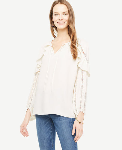 Intricate lace trim takes this ruffled romantic from everyday to extraordinary. Split neck with self ties and shirring beneath. Long sleeves. Front and back ruffles. Lace trim at shoulders and sleeves. 25 1/2 long.