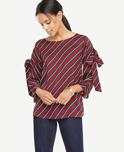 Tie sleeves add an alluring twist to this smartly striped top. Boatneck. 3/4 sleeves with self ties. Side slits. 24 1/2 long.