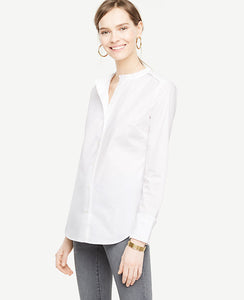 A crisp cotton shirt is an essential every closet needs - especially when it's embellished with pretty ruffles. Ruffle stand collar. Long sleeves with shirred ruffle cuffs and button closure. Button front. Shirred ruffle front shoulder yoke. Back yoke. Shirttail hem. 27 3/4 long.