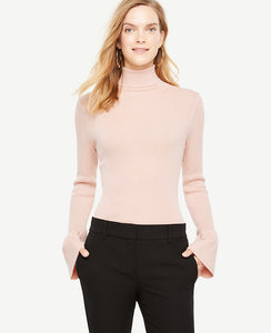 A sleek turtleneck meets wide flare cuffs for a perfect play on volume and proportion. Turtleneck. Long sleeves with flare cuffs. 25 long.