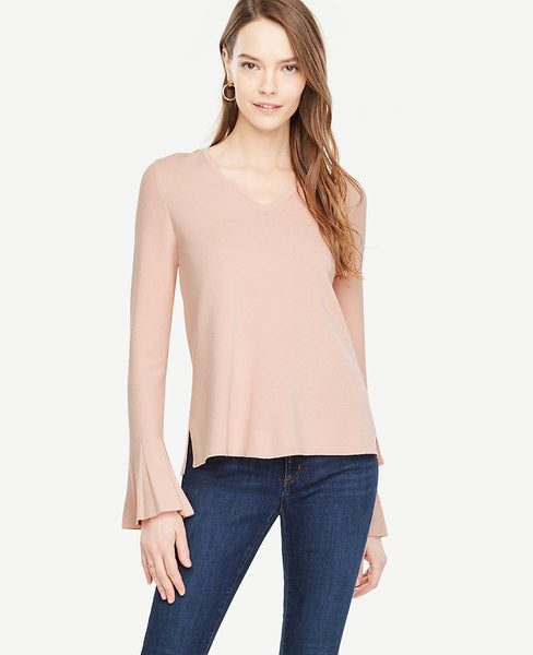 Our bell sleeve sweater is finished with elongated pleated cuffs - a modern way of adding volume. V-neck. Long sleeves with pleated cuffs. Side slits. Hi-lo hem. 24 front length; 26 back length.