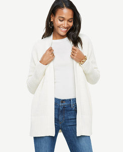 A textured waffle stitch adds warmth and refinement to our easy-to-layer open cardigan. Open front. Long sleeves. Drop shoulders. Vertical on-seam pockets. Side slits. Ribbed cuffs and hem. 28 1/2 long.