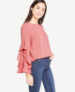 Cascading ruffle sleeves add modern fluidity to this romantically refined top. Boatneck. Long ruffle sleeves. Shirttail hem. 25 long.