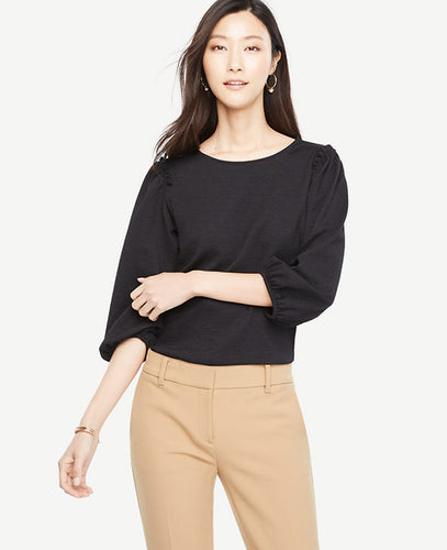 Our textured knit top turns up the volume with shirred puff sleeves and pretty shoulder ruffles. Jewel neck. 3/4 sleeves with shirred sleeve caps and cuffs. Shirred ruffle at shoulders. 23 1/4 from natural waist.