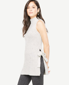 Meet your real-life uniform: this is Luxewear. Every day. Every wear. Side ties add a perfectly feminine twist to this rich tunic sweater. Mock neck. Sleeveless. Side slits with ties. 27 1/2 long.