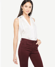 Polished pleats take this halter style to a new level of refinement. Split neck with pleated ruffle collar. Sleeveless. Front and back pleats. 25 3/4 long.