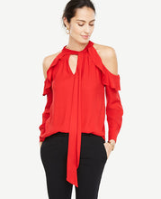 A romantic tie neck and shoulder-baring cutouts take this beautifully draped blouse to the top of our wish list. Stand collar with self tie. Long sleeves with button closure. Raglan ruffle seams with pleats beneath. Shirttail hem. 27 long.