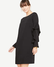 Cascading ruffle sleeves add the perfect wave of romance to this party-ready shift dress. Boatneck. Long sleeves. Back slit with button closure. Lined body. 19 from natural waist.