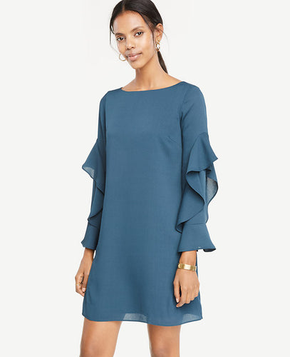 Cascading ruffle sleeves add the perfect wave of romance to this party-ready shift dress. Boatneck. Long sleeves. Back slit with button closure. Lined body. 19 1/2 from natural waist.